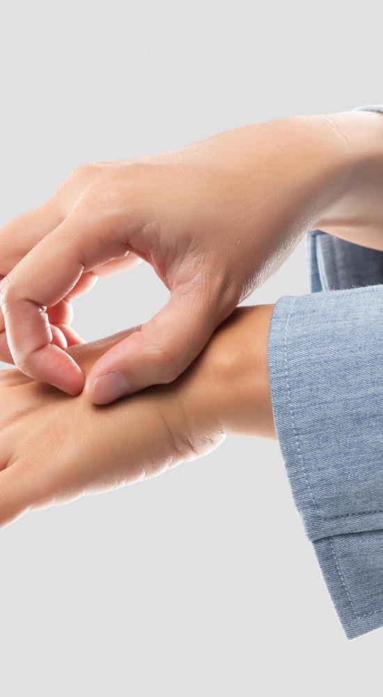 Businesswoman scratching her back of hand because of the itching from irritation. The concept of healthcare and medicine