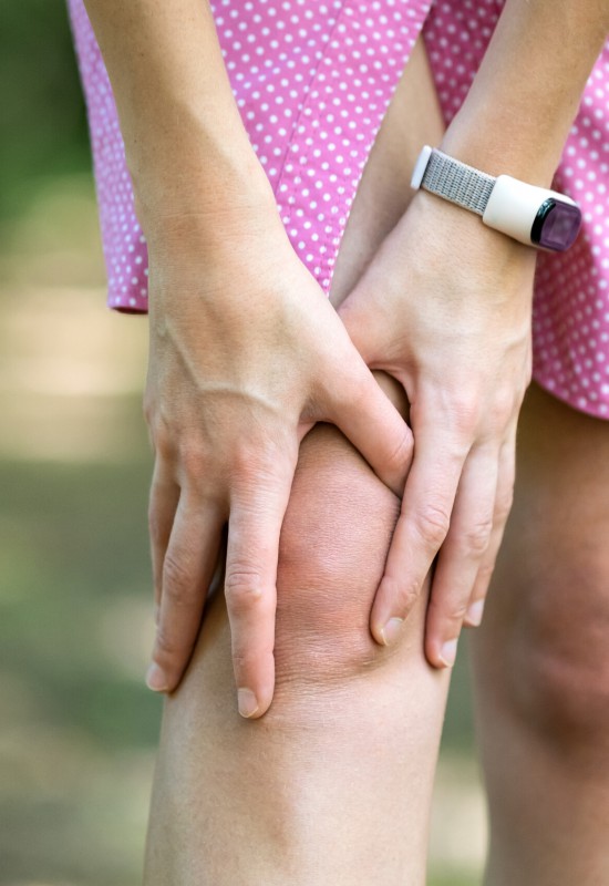 Woman holding her knee with hands having strong pain. Woman holding her knee with hands having strong pain.